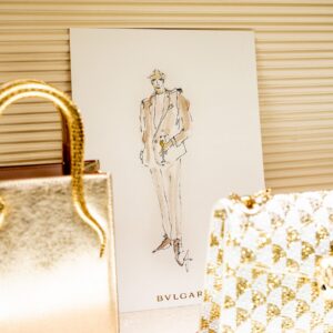 Live Fashion Illustration von Nadja König auf BVLGARI Karte neben einer goldenen Serpenti Tasche