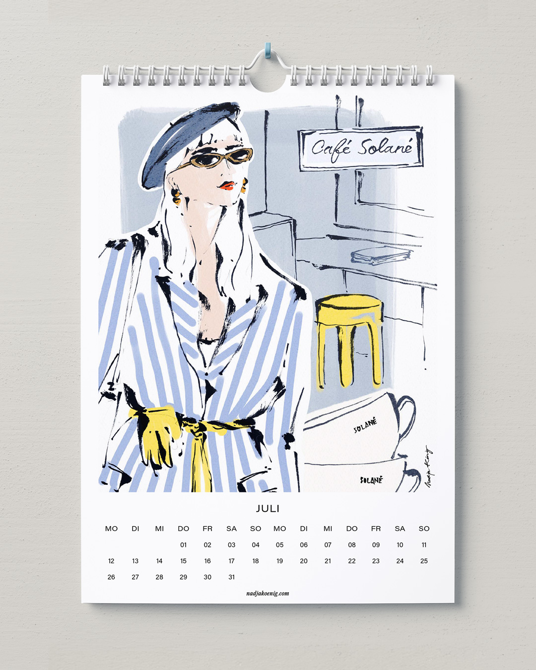 Wandkalender 2027 von Nadja König, Juli: Frau mit Baskenmütze und gestreiftem Hemd vor einem Café