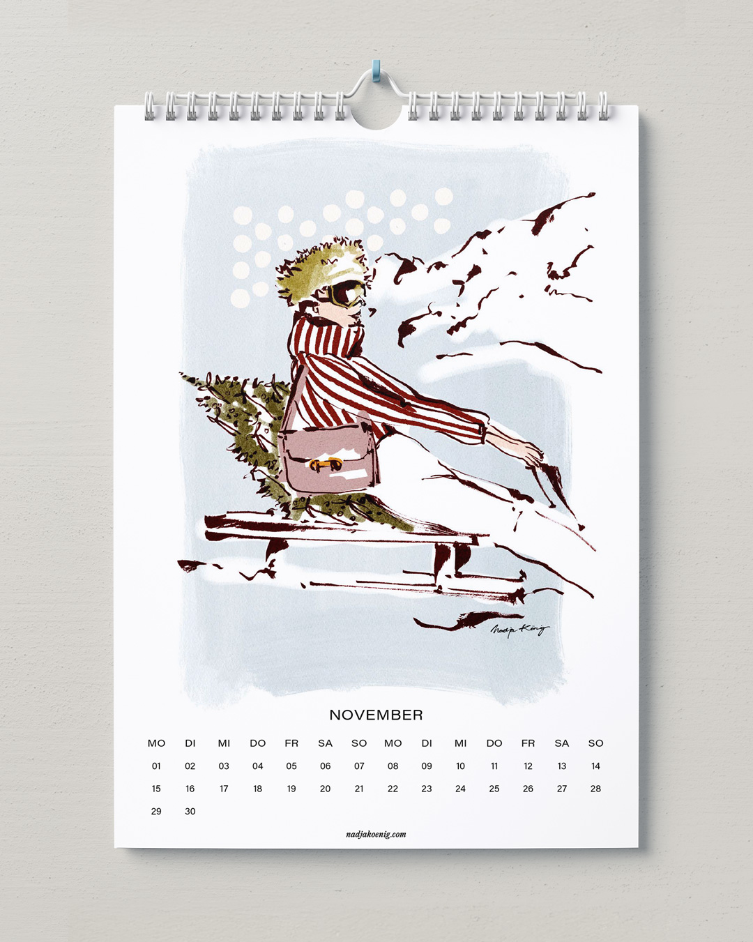 Wandkalender 2027 von Nadja König, November: Frau mit Mütze und gestreiftem Schal in einer Winterszene